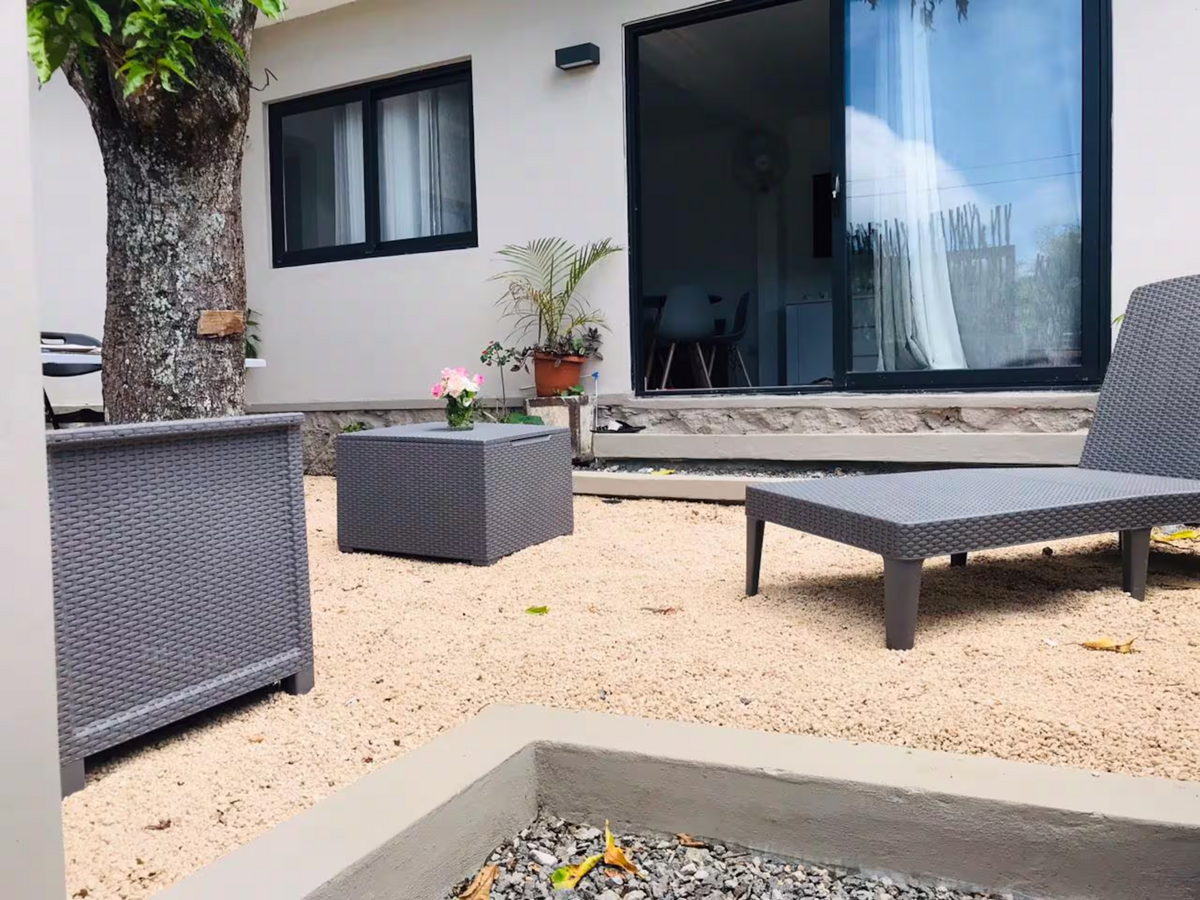 Patio at Serenity Cozy Cove with outdoor lounge seating beneath a tree